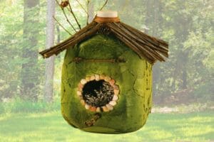bird feeder made from recycled milk jug, covered with leaves, pebbles, and twigs