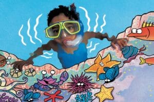 kid wearing a mask with a snorkel underwater exploring tidepool creatures