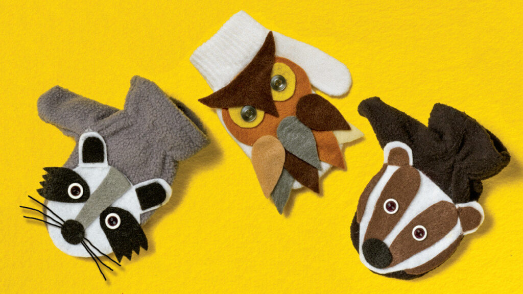 Three animal mitten puppets made from felt showing a raccoon, great horned owl, and badger