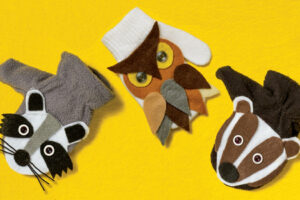 Three animal mitten puppets made from felt showing a raccoon, great horned owl, and badger