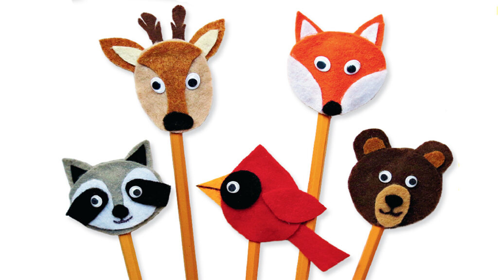 Five felt animal pencil toppers featuring a deer, fox, raccoon, cardinal, and bear