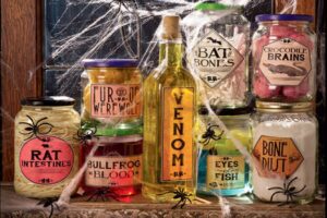 Halloween specimen jars on windowsill with labels like Rat Intestines Venom Bat Bones and Chicken Brains