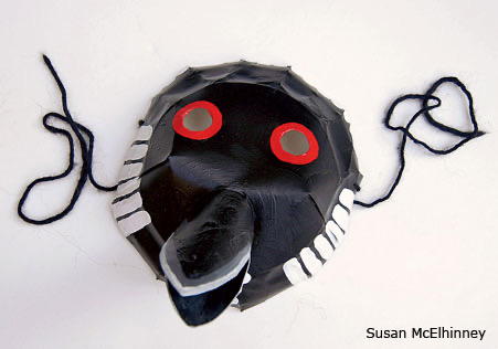 Handmade black loon bird mask with red eyes and beak made from craft materials
