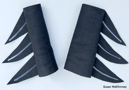 Pair of black craft foam wing cuffs with feather shapes for a loon costume