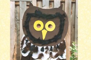 Handmade brown owl mask with yellow eyes and real feathers for kids craft project