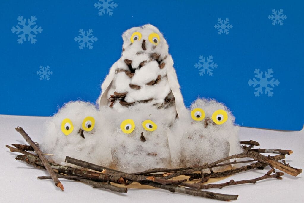 Pine cone snowy owl family craft with cotton ball owls yellow googly eyes in twig nest