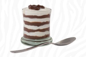 Layered chocolate and vanilla zebra striped pudding in a glass with a spoon